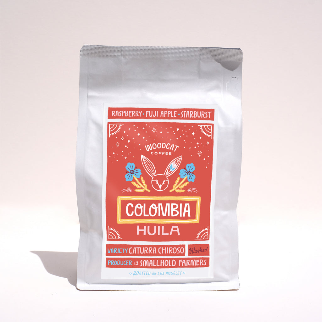A front view of a white coffee bag with a red label that reads "colombia huila"