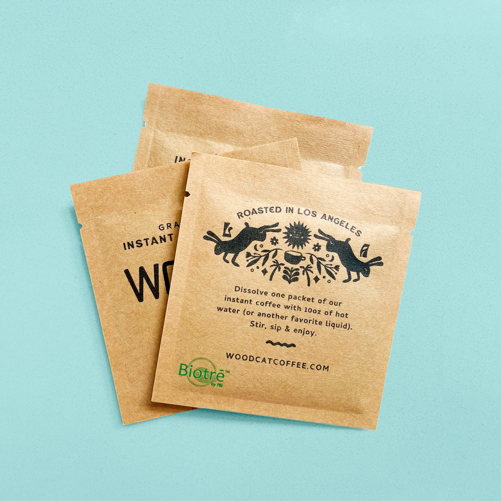 3 brown paper sachets layered on top of a mint green background