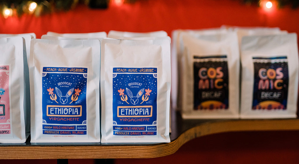 White coffee bags with blue vertical labels that read "ethiopia" sitting side by side on a wooden shelf