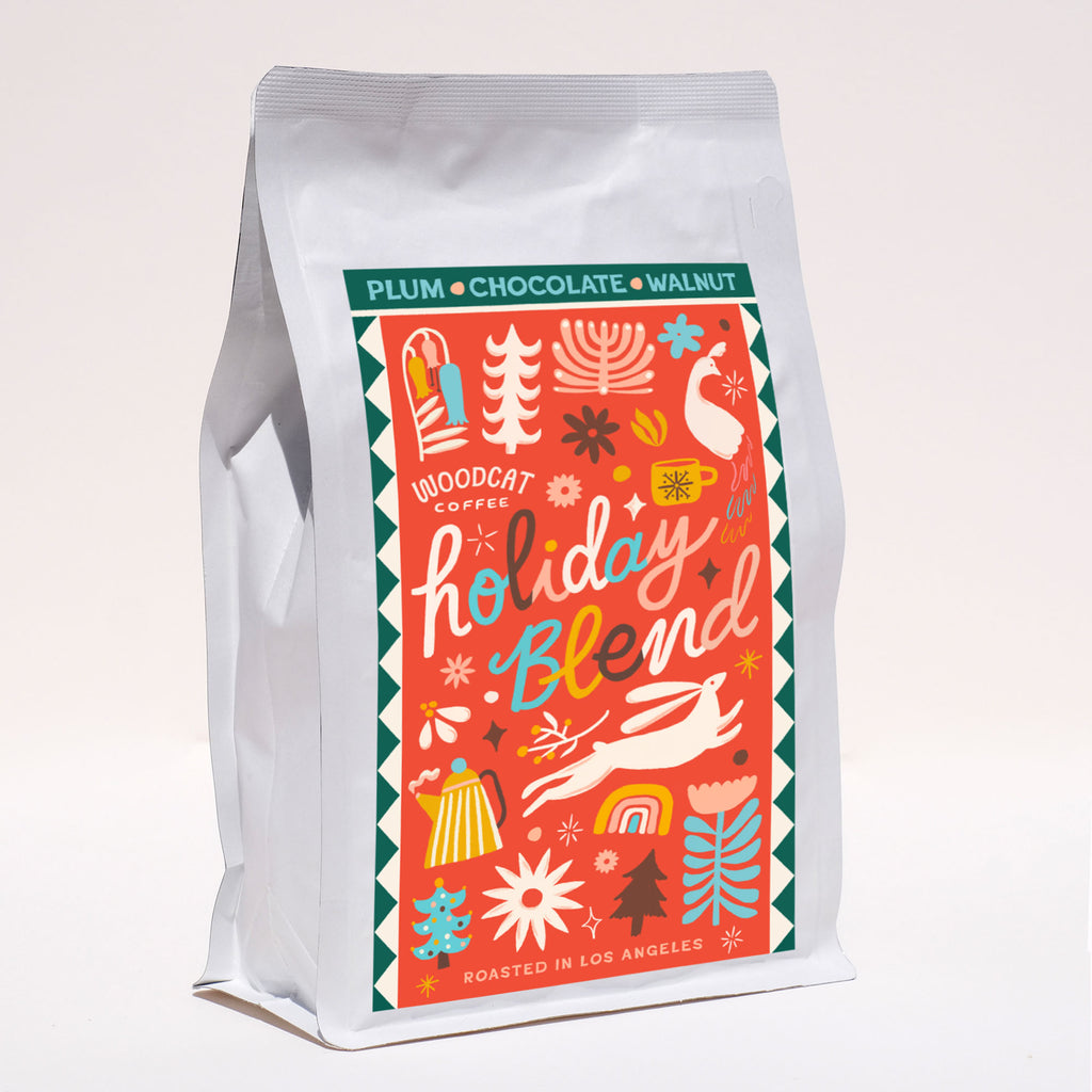 A white bag with a red label containing christmas-themed illustrations. 