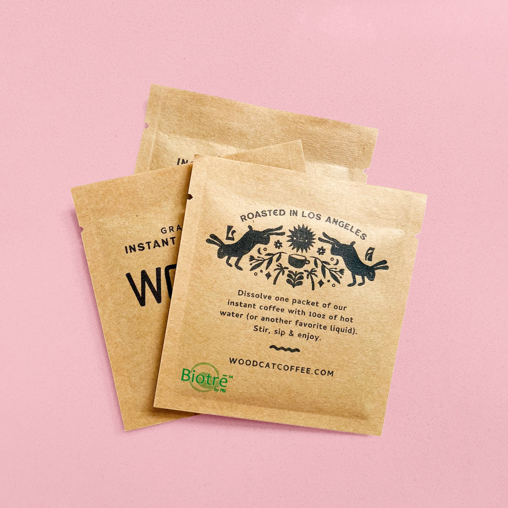 Three square brown paper sachets atop a pink background
